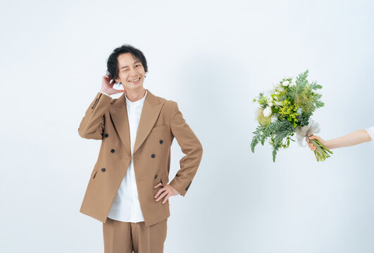ブーケを渡されて照れる男性　ブライダルフォト　ウェディングフォト　前撮り
