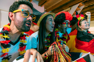 Group of enthusiastic German soccer fans celebrating the victory