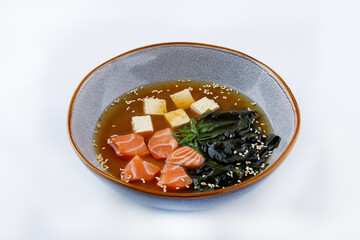 Closeup on appetizing ishikari miso soup with salmon in a black bowl, horizontal