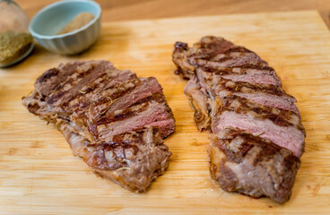 Chef at the kitchen preparing beef steaks on the home electric grill