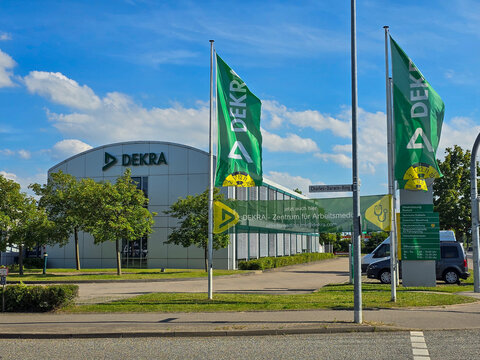 building of the expert organisation company DEKRA with flags at a sunny day on 30th of June in Rostock, Germany