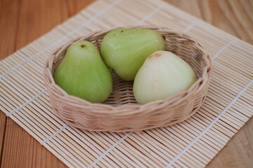 A water guava resting in a tiny basket