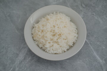 Cooked rice in a bowl background, top view.