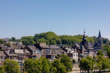 Obraz premium Summer cityscape with view of Vise city in Belgium under blue sky, Architecture traditional house and church along the Meuse river, Visé is a city and municipality of Wallonia in the province of Liège