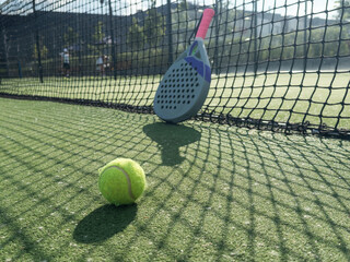 paddle tennis racket and balls on court 