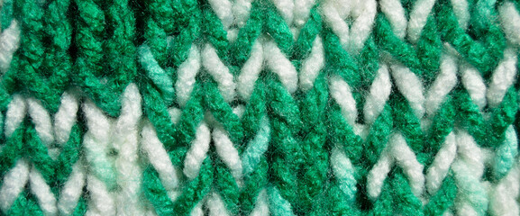 Handmade knitted fabric green and white wool background texture