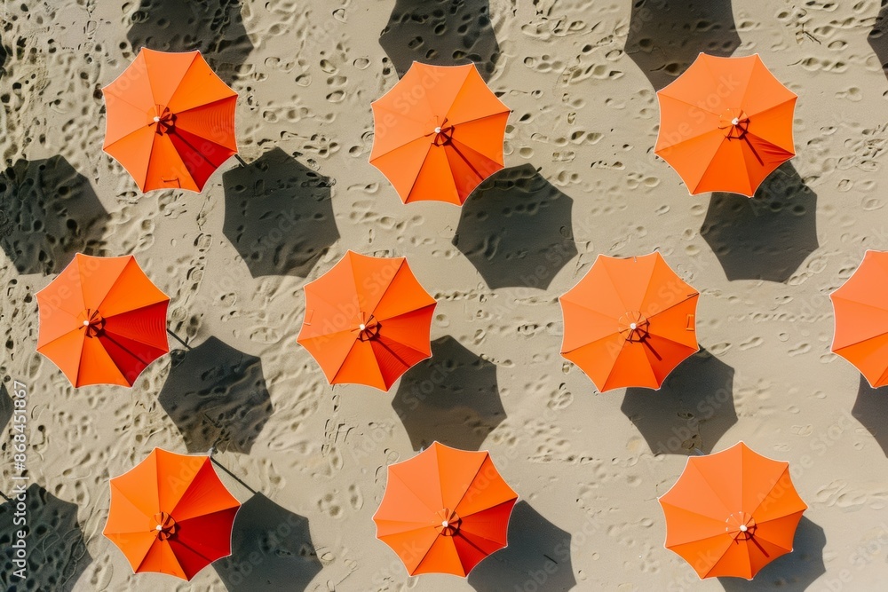 Poster bright orange beach umbrellas on sandy shore a pattern of consistent spacing and soft shadows evokin