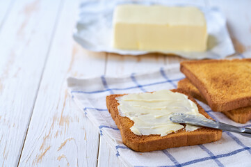 Delicious crispy toast bread and fresh butter on cutting board.
