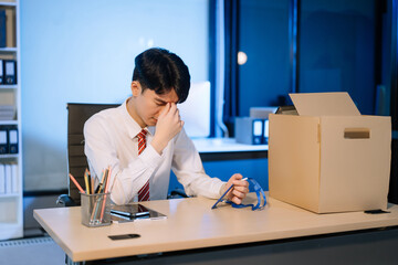 young  Asian man office worker celebrating her resignation, carrying her personal stuff. leaving job, changing or company