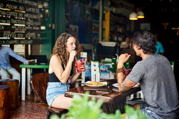 Restaurant, food and couple for eating on date, hangout and chilling together for bonding with meal. Relationship, boyfriend and girlfriend with beverage, hungry and lunch in Germany for people