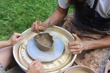 creative master class on pottery. hands that knead clay. Potter's wheel. process of making a clay product. Joint creation.