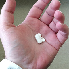 There are a lot of pills in the hospital patient's hand. Hospital concept