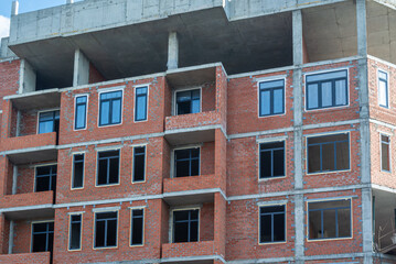 Red brick is used for the construction of exterior walls and partitions in buildings under construction.  The frame of the building is made of reinforced concrete. Installation of plastic windows.