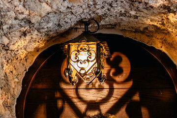 Aged brass light fixture in a stone archway casting intricate shadows, creating vintage elegance
