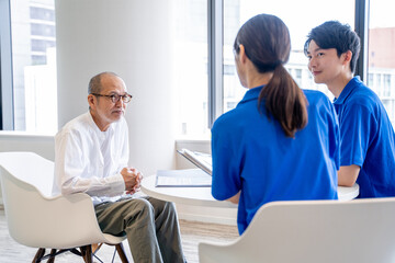 Obraz premium 談話する介護スタッフとシニア男性