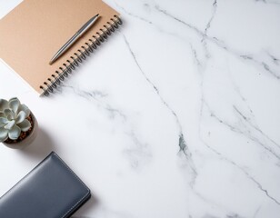 大理石デスクに置かれたノートや植物