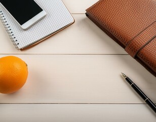 散らばって置かれたオレンジと手帳とスマホ