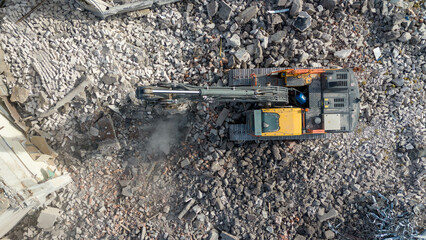 Drone photography pf machinery demolishing a building during spring day