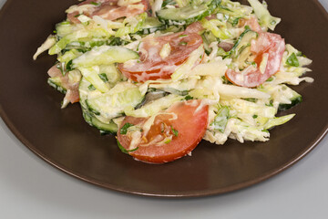 Salad of fresh vegetables on brown dish on gray background