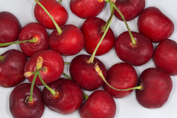 Dark red sweet cherries on stems, top view close-up