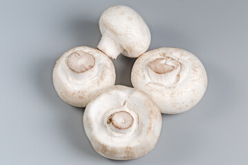 Whole fresh raw button mushrooms on a gray background