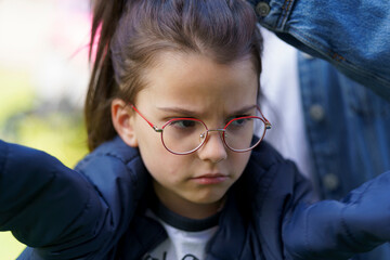 Little sad teenager girl wearing glasses outdoor