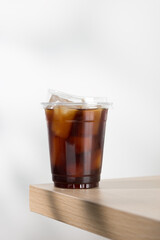 Iced americano in clear cup on wooden table.