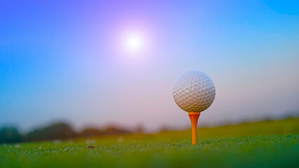 Golf ball on tee in a beautiful golf course with morning sunshine.