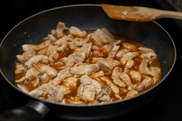 Cooking chicken in a frying pan for dinner, chicken and brown sauce 