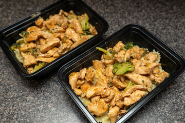 Meal Prep chicken and broccoli in a black meal prep container. Lunch for work, healthy food.