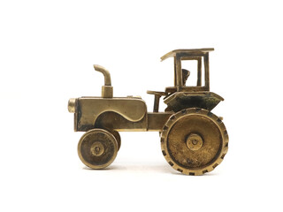 toy model of an old rusty tractor truck used by farmers for agriculture made of golden metal isolated in a white background