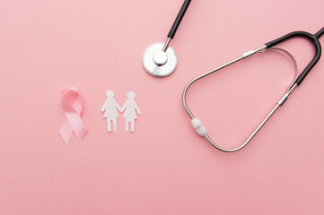 breast cancer campaign pink background with women paper silhouettes, stethoscope and cancer pink ribbon