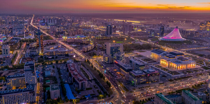 The night aerial view of Astana downtown (the Republic of Kazakhstan), with Khan Shatyr shopping mall, Astana opera house, Kabanbay Batyr avenue, the beautiful city lights and scenic sky.
