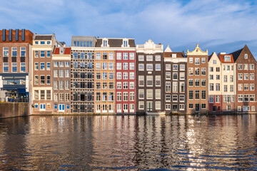 Scenery of Damrak in Amsterdam, Dutch. The houses located direct on the water