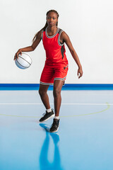 Obraz premium Vertical photo female basketball player practicing dribbling techniques. Sport concept.