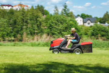 Man on lawn tractor mowing lawn on backyard. The red rider. The lawnmower tractor. High quality 4k footage