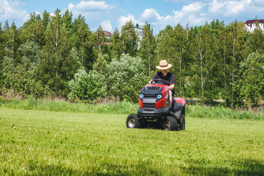 Man on lawn tractor mowing lawn on backyard. The red rider. The lawnmower tractor. High quality 4k footage