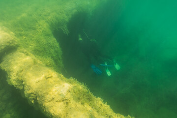 Underwater photo, divers swim into the flooded Rummu prison.