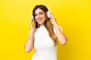 Caucasian woman isolated on yellow background listening music