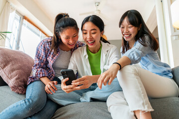 Happy beautiful chinese women friends bonding at home