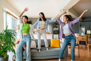 Happy beautiful chinese women friends bonding at home