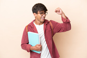 Young student caucasian man isolated on ocher background celebrating a victory