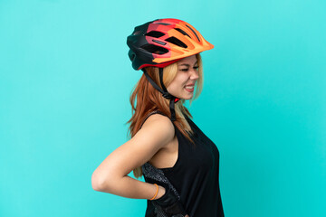 Young cyclist girl over isolated blue background suffering from backache for having made an effort