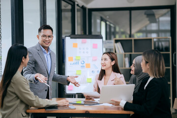 Professional team at and both male and female members participated in a lively brainstorming session at the company office. They collaborate on creative projects using modern technology.