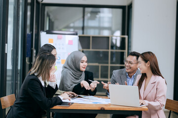 Professional team at and both male and female members participated in a lively brainstorming session at the company office. They collaborate on creative projects using modern technology.