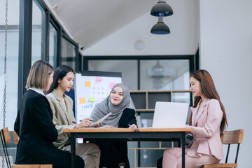 Professional team at and both male and female members participated in a lively brainstorming session at the company office. They collaborate on creative projects using modern technology.