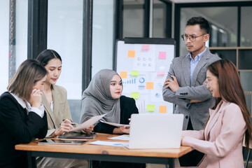 Professional team at and both male and female members participated in a lively brainstorming session at the company office. They collaborate on creative projects using modern technology.