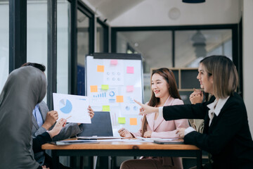Professional team at and both male and female members participated in a lively brainstorming session at the company office. They collaborate on creative projects using modern technology.
