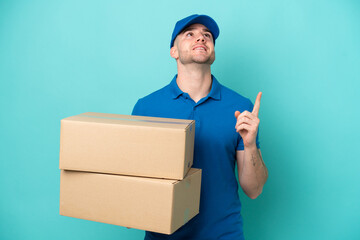 Delivery caucasian man isolated on blue background pointing up a great idea