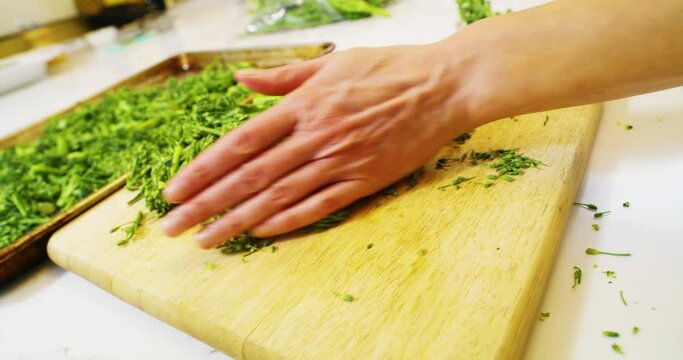 Chopping broccolini on cutting board
